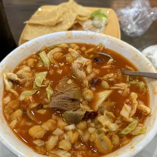 Pozole rojo with pork. Comes with onion, cabbage, lemon, chiles and oregano on the side that you can add