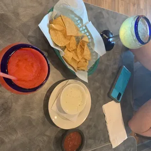 Chips and Salsa with Queso, House margarita on ice (tajine on the rim), and frozen strawberry margarita