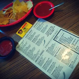 a menu and a bowl of chips