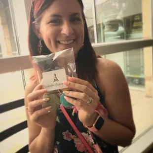 a woman holding a bag of macaron