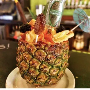 a pineapple with a drink in it