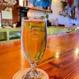 a glass of beer on a bar