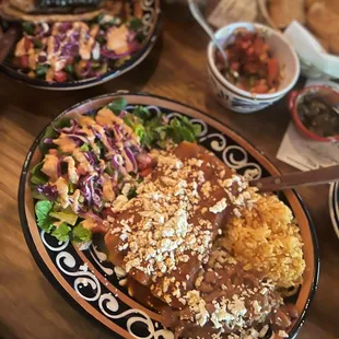 Enchiladas, arroz y frijoles with a side salad.