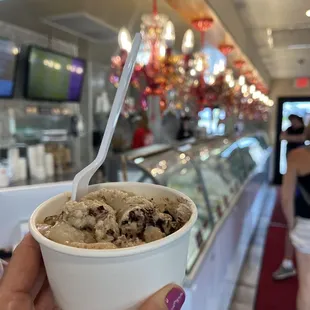 a person holding a cup of ice cream