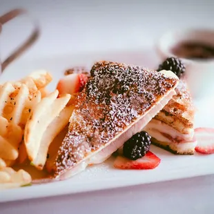 a plate of food with french fries and strawberries