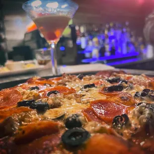 a pizza with olives and pepperoni