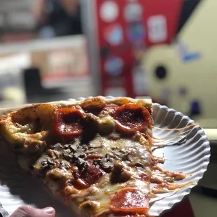 a slice of pizza on a paper plate