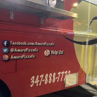 a red food truck with a smiley face painted on the side
