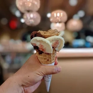 a hand holding a cone of ice cream