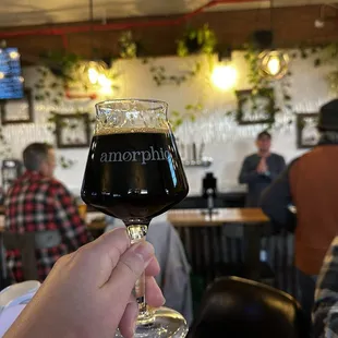 a person holding a glass of beer