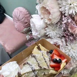 a person holding a box of dessert