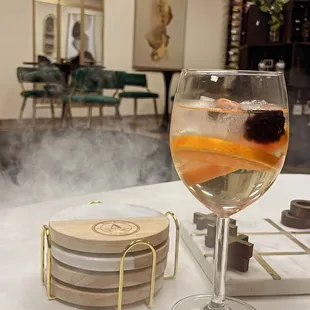 a glass of wine and coasters on a table