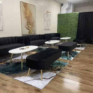 a living room with black couches and coffee tables