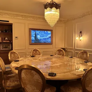 a dining room with a marble table and chairs