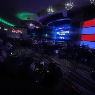 people sitting in chairs in front of a large screen