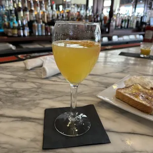 a glass of orange juice on a bar