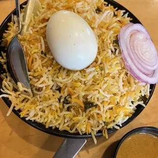 a plate of rice with an egg and onion
