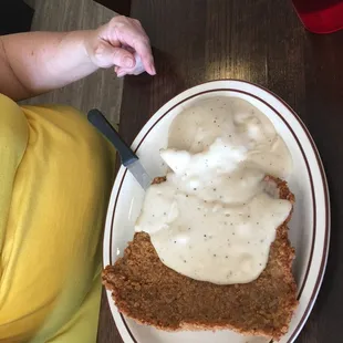 a woman sitting at a table with a plate of food
