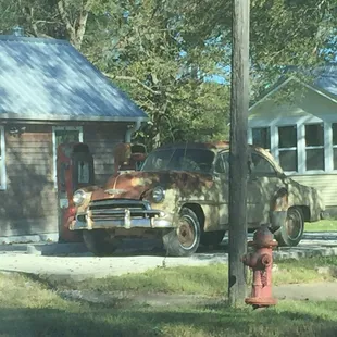 an old car parked in front of a house