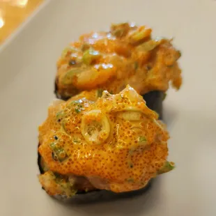 a hand holding a plate of sushi