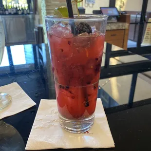 a glass of watermelon drink on a napkin