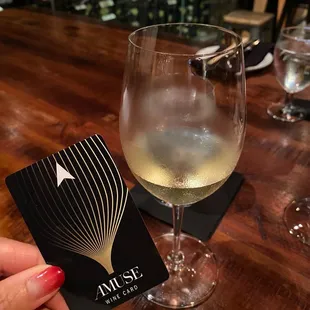 a glass of wine and a card