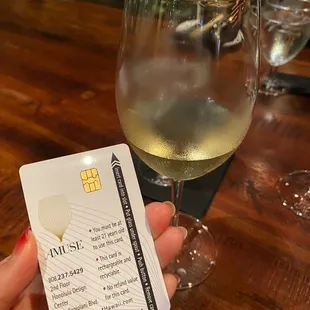 a glass of wine and a card