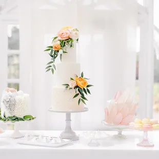 a three tiered wedding cake with fresh flowers