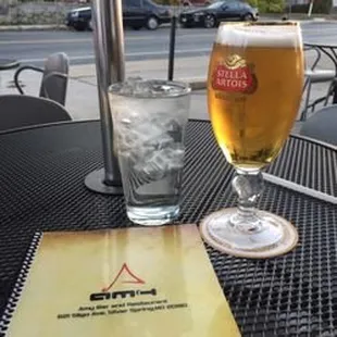 a glass of beer and a menu