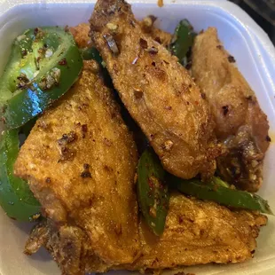 chicken wings and peppers in a styrofoam container