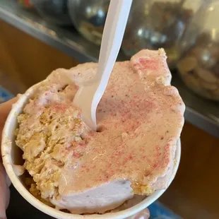 a hand holding a cup of ice cream