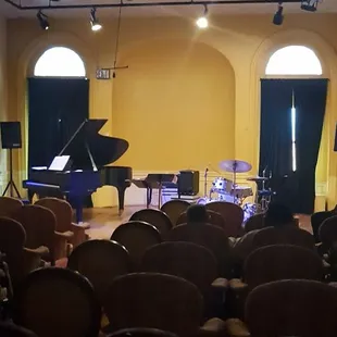 a stage with a piano and chairs