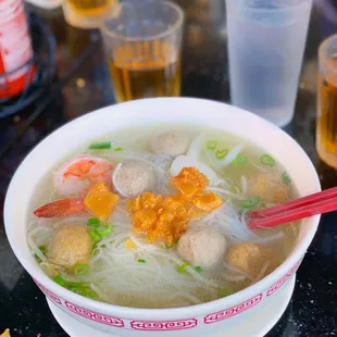 a bowl of soup with noodles and meatballs