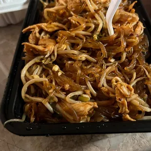 a tray of food with noodles and meat
