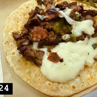 Tiny portion of discada meat in hard harina taco.