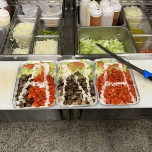 several trays of food being prepared