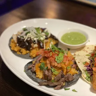 a plate of tacos and a bowl of sauce