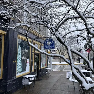 a snowy sidewalk with tables and chairs