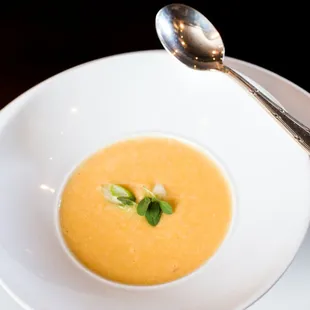 a bowl of soup on a plate with a spoon