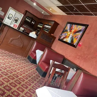 a restaurant with red chairs and a bar