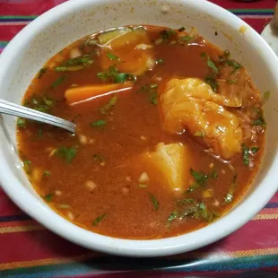 a bowl of soup with shrimp and vegetables