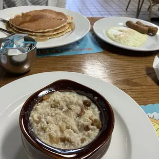 Oatmeal, pancakes, eggs, and sausage