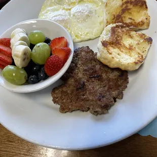 Eggs over easy with homemade sausage,fruit cup and delicious biscuit.