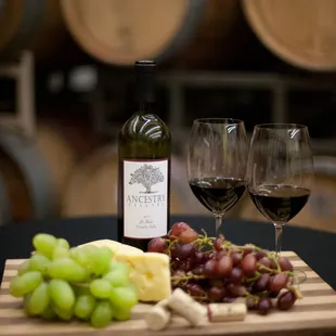 wine, cheese and grapes on a cutting board