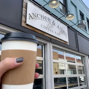 a hand holding a cup of coffee