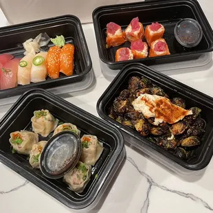 four containers of different types of sushi