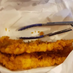 a pair of tongs in a paper bag