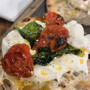 two pieces of bread topped with tomatoes and cheese