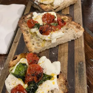 three slices of bread topped with tomatoes and cheese
