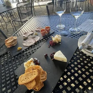 an assortment of cheeses, crackers, crackers, and wine